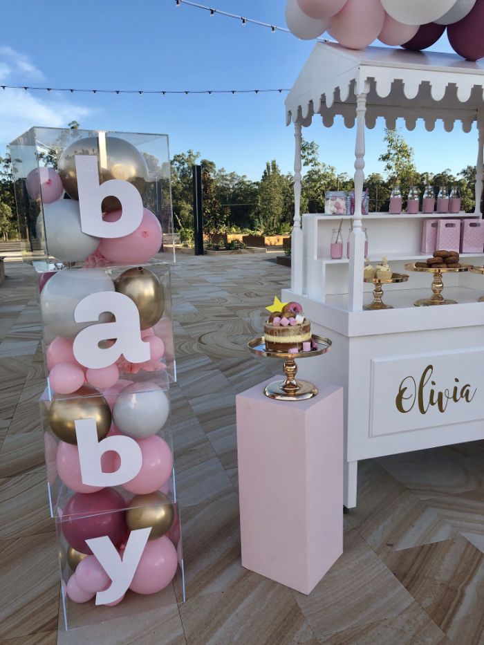 food cart with desserts cake next to it boy baby shower decorations baby blocks filled with pink gold white balloons