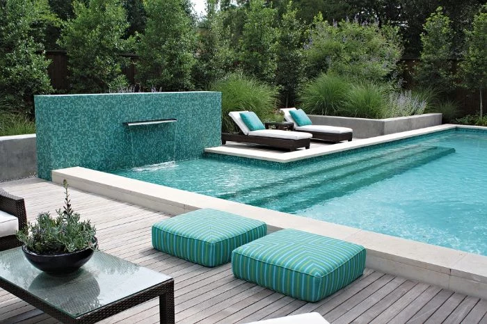 fountain and a pool with blue cushions and throw pillows on lounge chairs modern pool designs