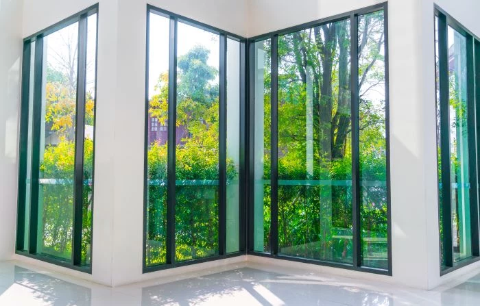 four tall glass windows overlooking green garden with black frames door installation