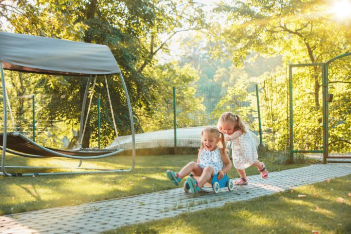 games to play outside two blonde girls playing one pushing the other one sitting on toy car