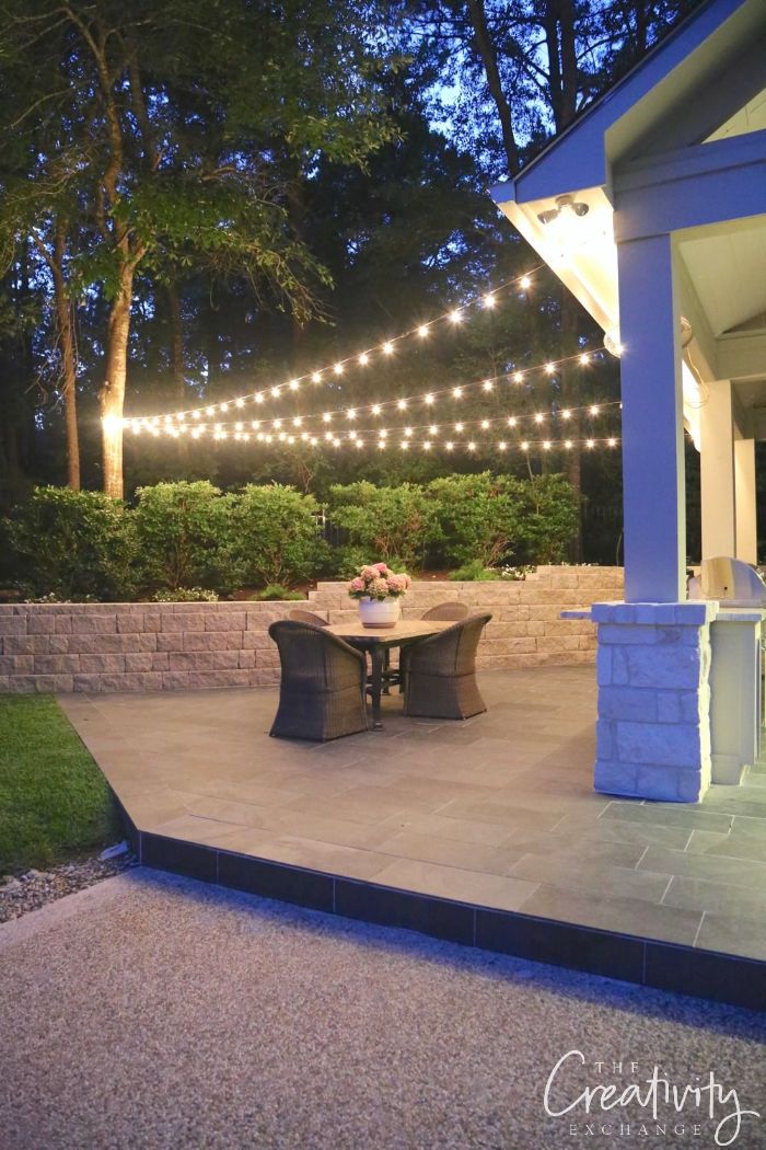 garden furniture on the back patio outdoor patio lights strings of lights hanging from a tree to the house