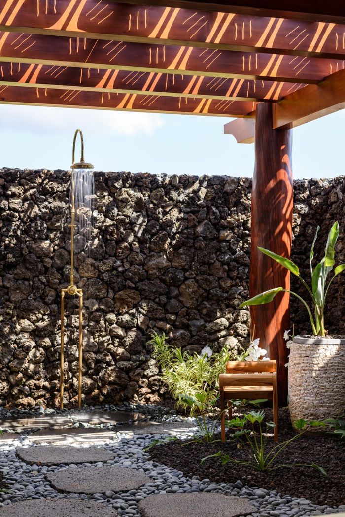 gold metal shower mounted on stone wall outdoor shower designs stone tiles and rocks on the floor