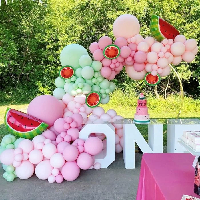 green pink white balloons forming and arch over desserts table baby shower table decorations watermelon theme
