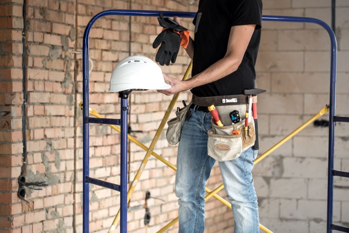home remodeling builder handyman with construction tools in bag around his waist