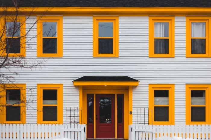 home siding white siding on house with windows with yellow frames red door