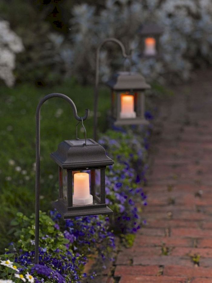 how to hang string lights on covered patio lanterns with solar candles inside hanging in the flower beds along a pathway