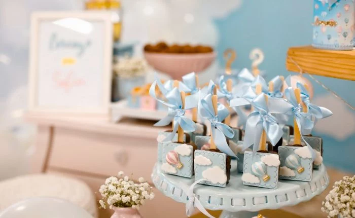 lollipops decorated with blue ribbons blue icing placed on cake stand baby shower ideas for girls hot air balloon theme
