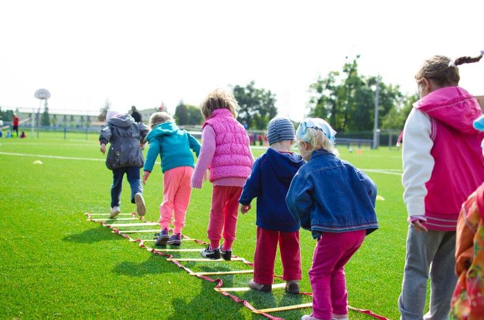 lots of kids playing on a field covered with grass outdoor games for kids ladder spread onto the grass