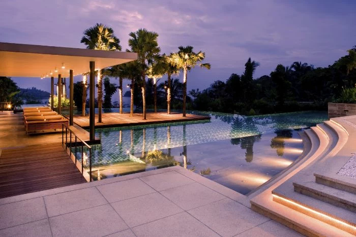 lots of lights inside a pool with deck with tall palm trees modern pool designs wooden deck with lounge chairs