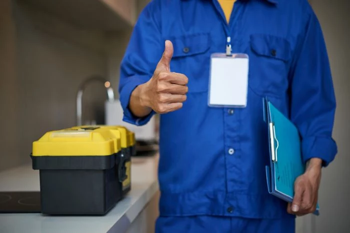 man wearing blue protective gear standing next to toolbox home remodeling holding folder