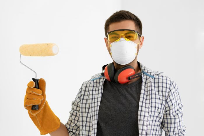 man with brown hear wearing protective equipment against lead poisoning mask glasses head set