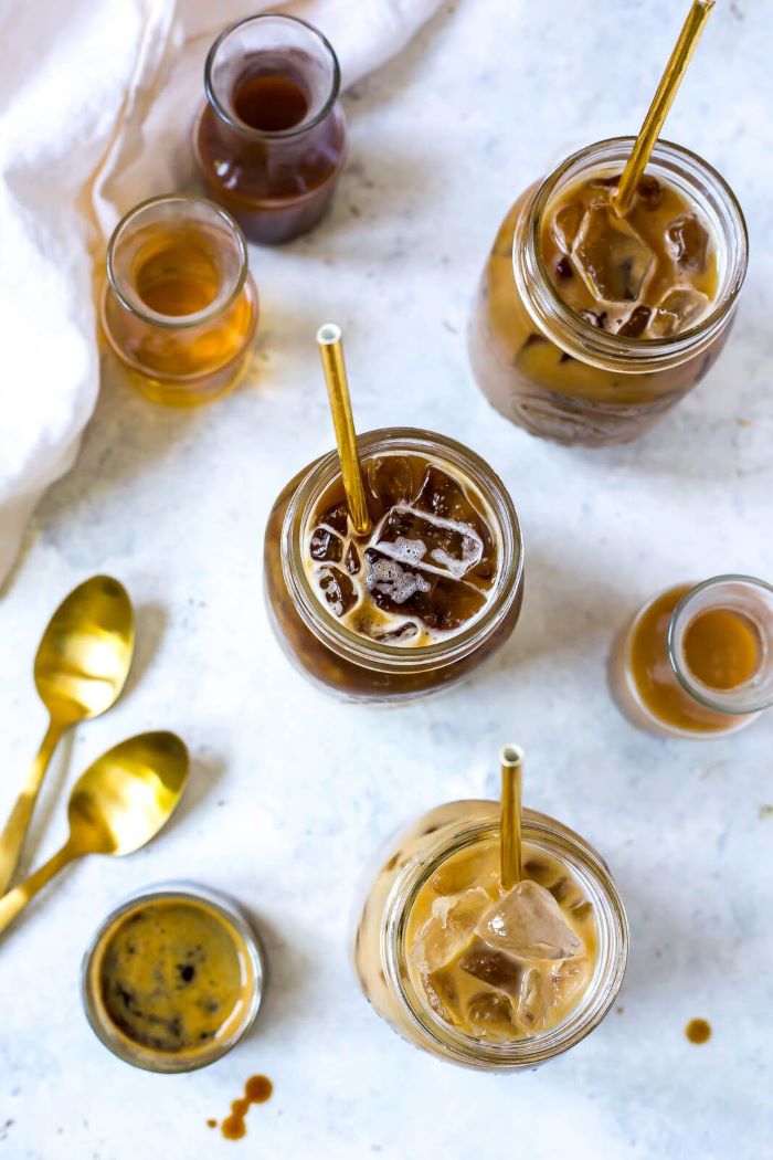 mason jars filled with coffee and ice cold brew coffee placed on granite surface