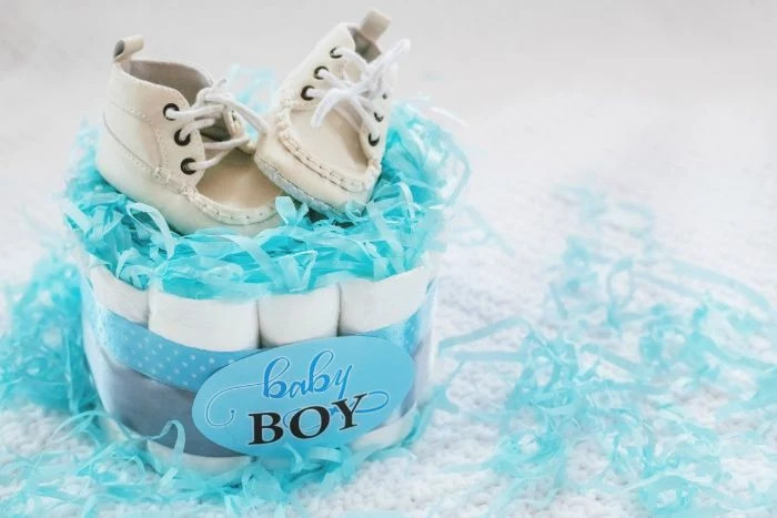 mini diaper cake decorated with blue and gray ribbon blue tissue paper baby shower ideas for girls two baby shoes on top