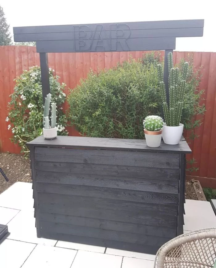 minimalistic bar made with black wood siding backyard bar ideas potted succulents on it