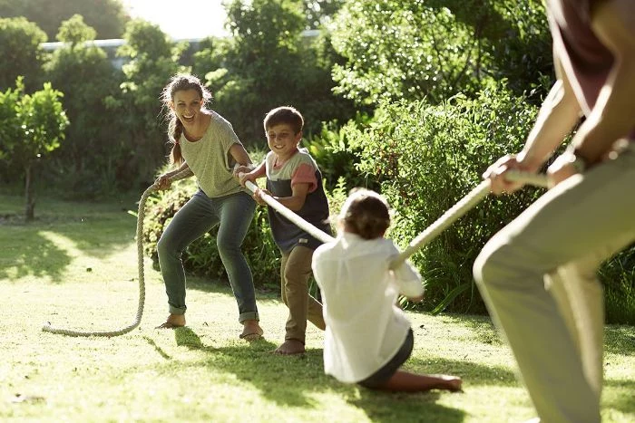mom dad and kids playing tug of war outdoor fun for kids holding onto a rope on both ends