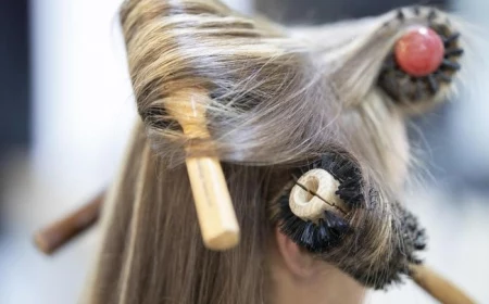 most iconic looks close up photo of woman with blonde hair being styles with three brushes