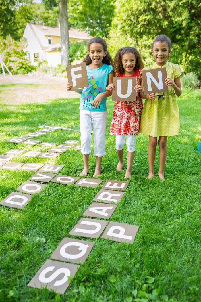 outdoor activities for toddlers three girls holding up boards with letters spelling fun outside scrabble