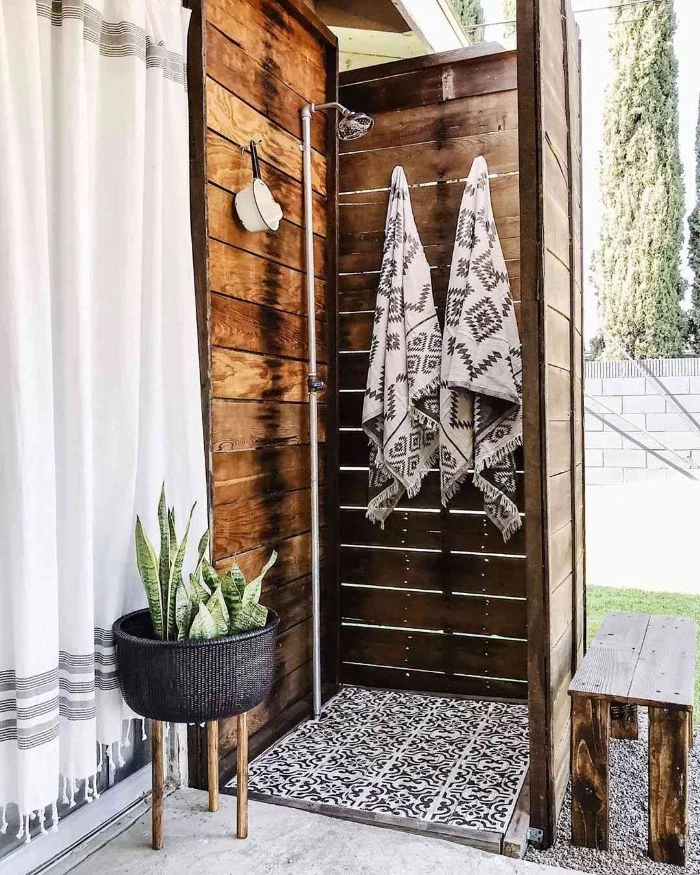outdoor shower enclosure wood enclosure tall with hooks for towels metal shower black and white tiled floor
