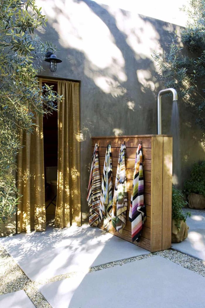 outside showers wood half wall with colorful towels hanging from it outside showers metal tube for shower