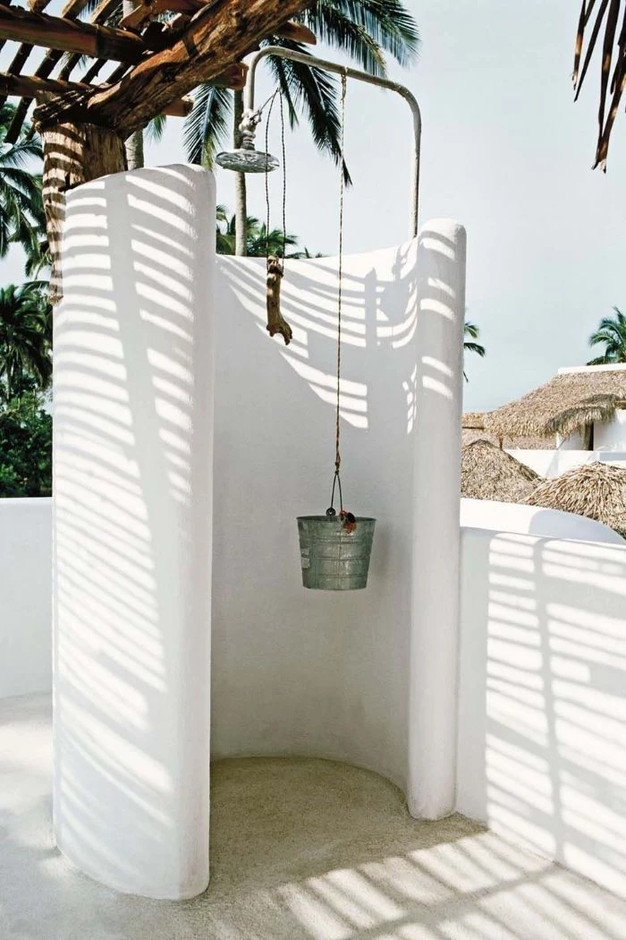 round enclosure in white how to build an outdoor shower bucket hanging from it underneath lots of palm trees