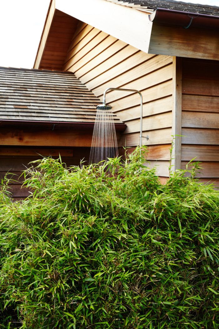 shower mounted on the wood wall on the side of the house outdoor shower designs hid behind bushes