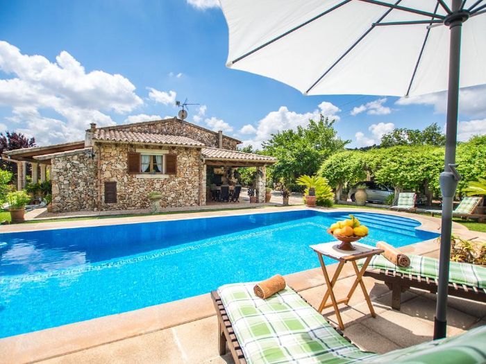 small backyard pools large pool next to house made of stone two lounge chairs with large umbrella next to pool