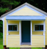 small house covered with yellow siding home siding blue frames on door windows roof