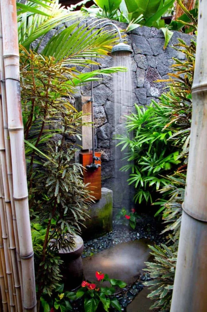 stone wall with shower mounted on it building an outdoor shower surrounded by plants
