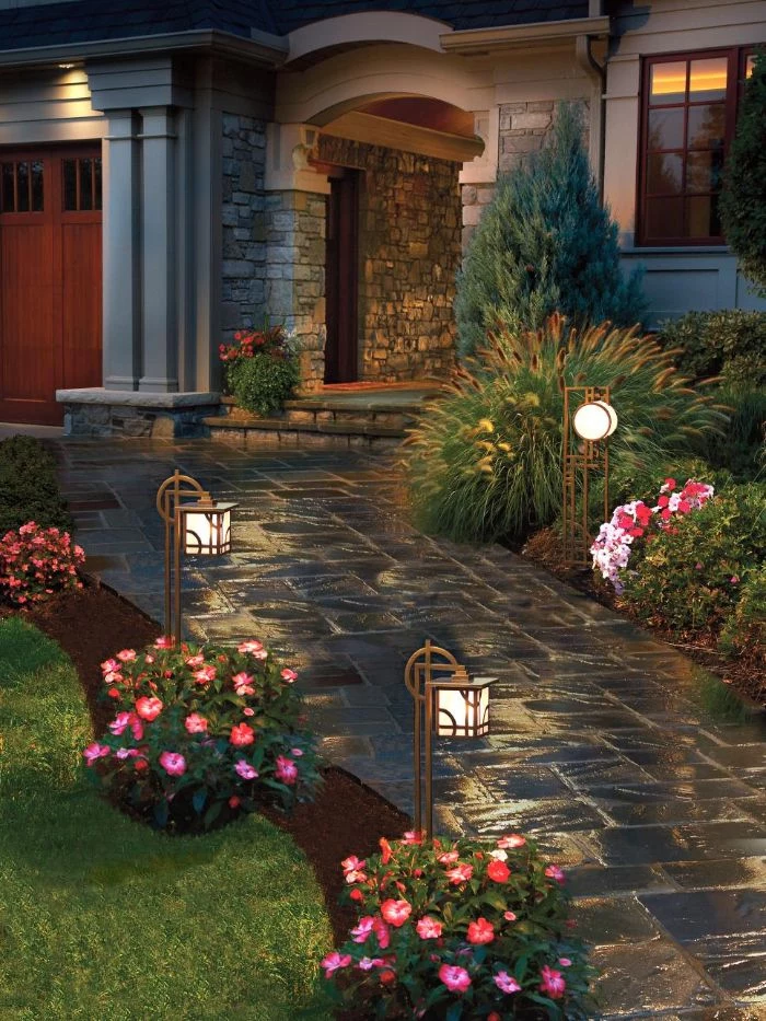 string light pole stone pathway leading to the door flower beds mini lanterns around it