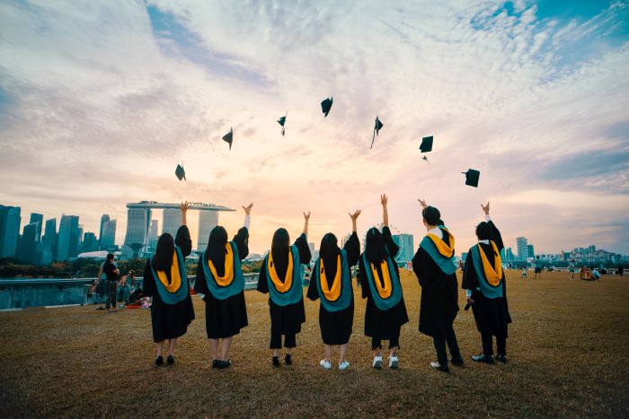 study architecture seven university students graduating throwing their hats in the air