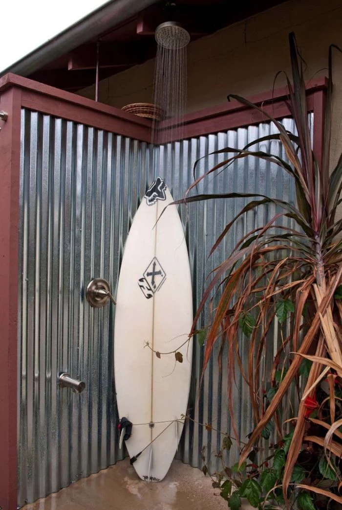 surf leaning on metal enclosure diy outdoor shower shower head above it