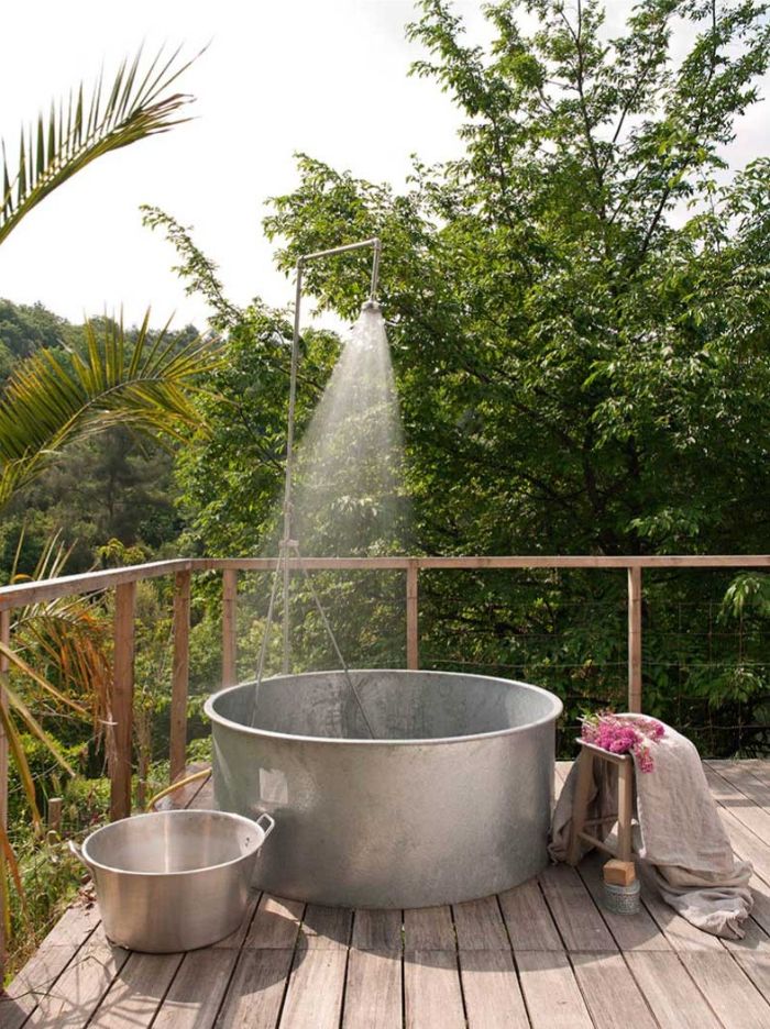 terrasse made of wood with large metal tub metal shower head on top outdoor shower enclosure