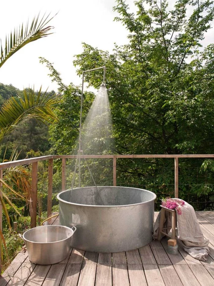 terrasse made of wood with large metal tub metal shower head on top outdoor shower enclosure