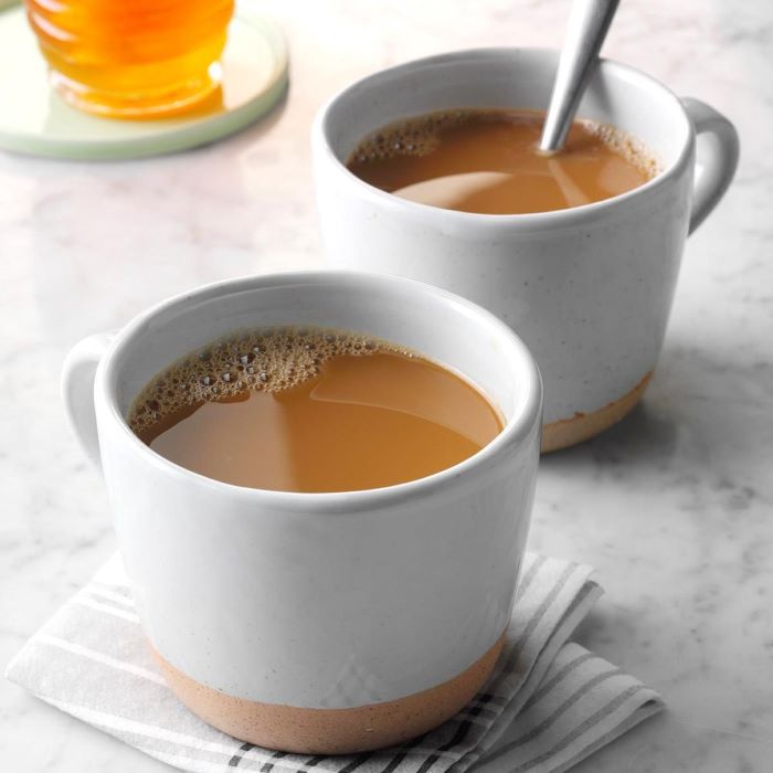 two mugs of coffee with milk cold brew coffee placed on white granite countertop