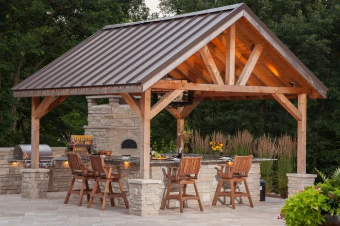 wooden enclosure over outdoor kitchen build with stone outdoor kitchen bar wooden chairs