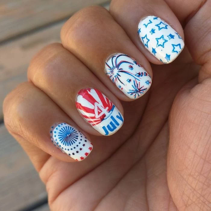 blue and red stars and fireworks 4th of july nails drawn on white nail polish base