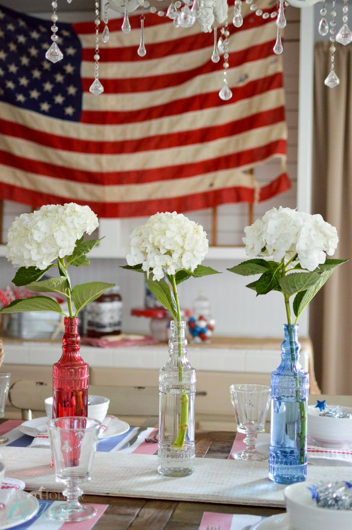 blue white red vases in the middle of the table 4th of july crafts american flag in the background