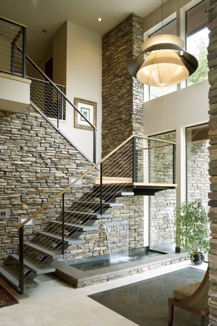 brick wall made of stones tall staircase pond underneath it indoor water features water falling from the wall to the pond