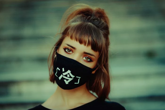 brunette woman with bangs hairs in half ponytail women fashion for summer 2021 wearing black face mask