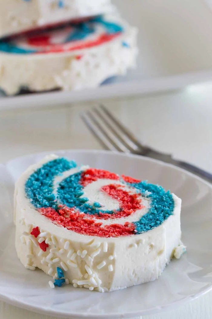 cake roll with red and blue in the middle white frosting on top 4th of july desserts red white and blue sprinkles