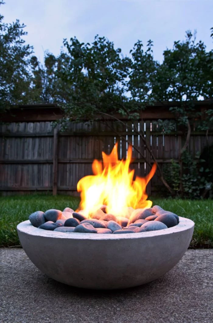 concrete bowl filled with rocks fire burning inside fire pit seating ideas step by step diy tutorial