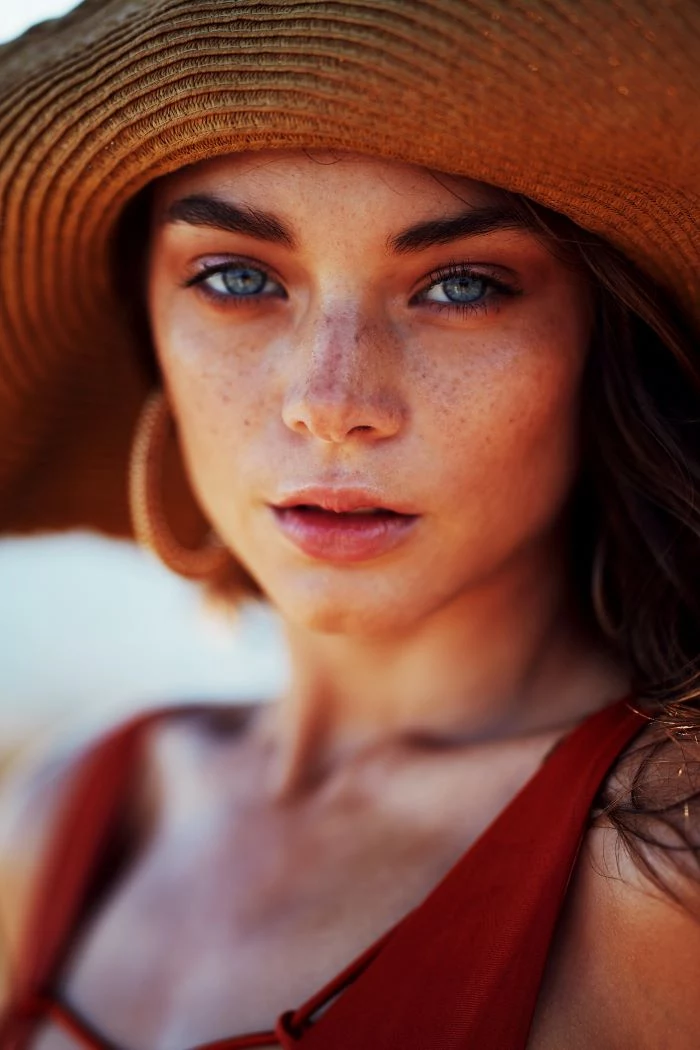 discovering you skin type woman with blue eyes lots of freckles on her face wearing red top