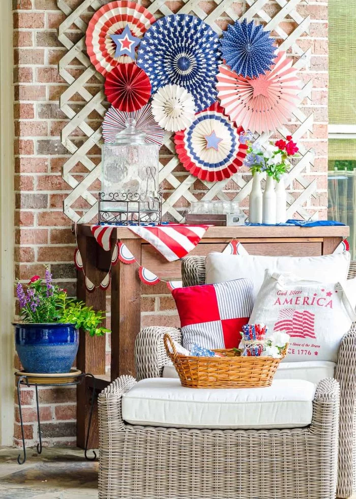 fourth of july decorations paper fans in red white blue with stars stripes hanging above garden furniture