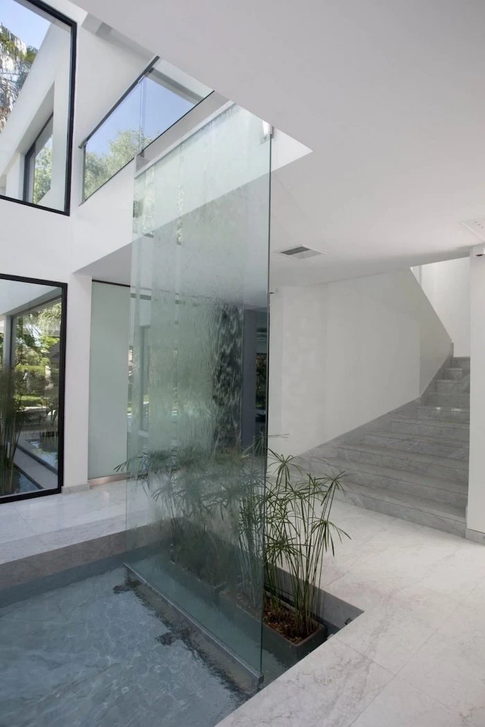 glass room divider in pond in the hallway indoor waterfall water flowing down the glass