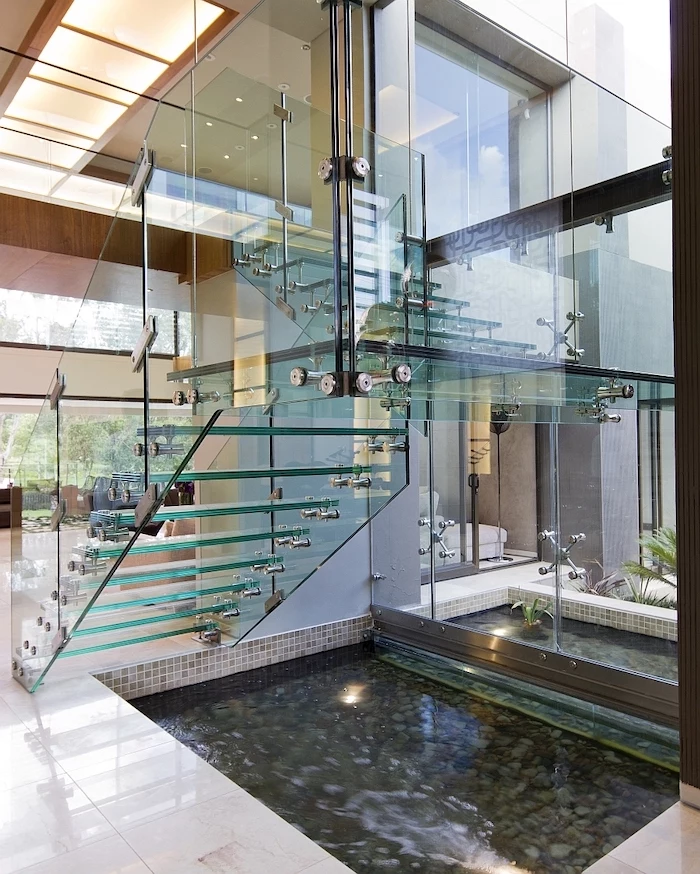 glass staircase tall windows tabletop fountain small pond under the stairs with fountain inside