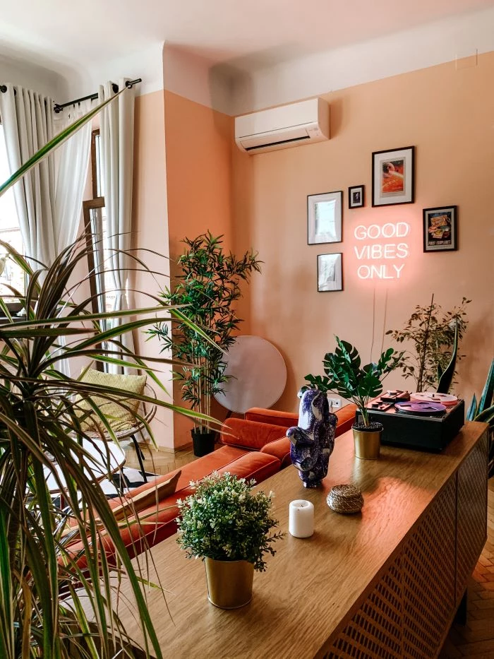 good vibes only neon sign photos around it décor ideas for living room lots of plants in the living room