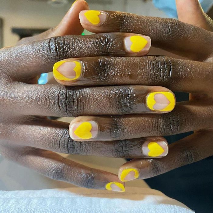 hearts in negative space made with yellow nail polish summer nail ideas short nails