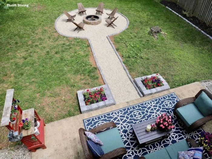 homemade fire pit seating area with wooden lounge chairs arranged around round fire pit made of stones