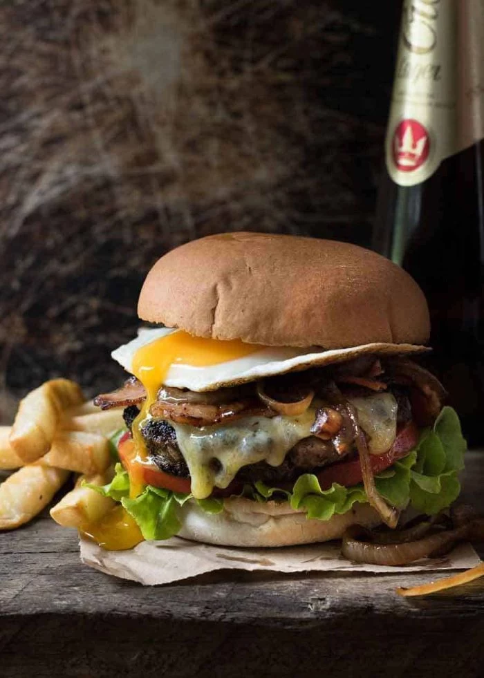 juicy burger with melted cheese egg tomatoes lettuce grilled onions bacon homemade burgers