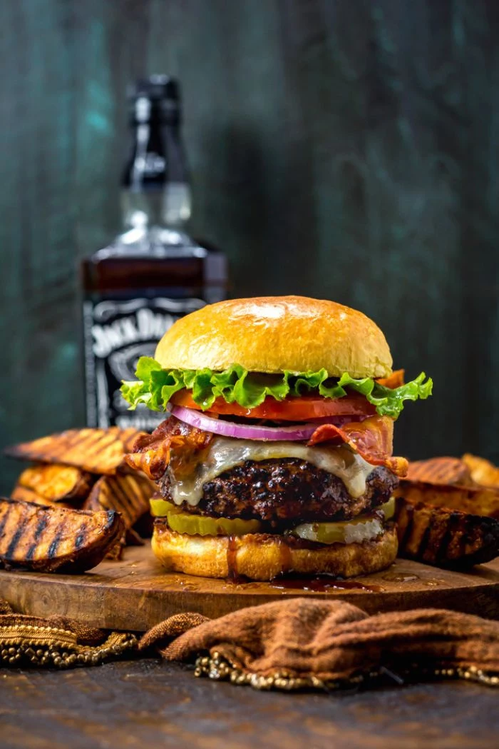 large burger with cheese bacon onions tomatoes lettuce hamburger recipes placed on wooden board